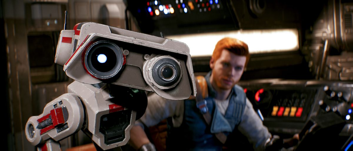 il droide BD-1 che guarda verso la telecamera, con Cal Kestis dietro di lui seduto ai comandi di un'astronave, in Star Wars Jedi: Survivor