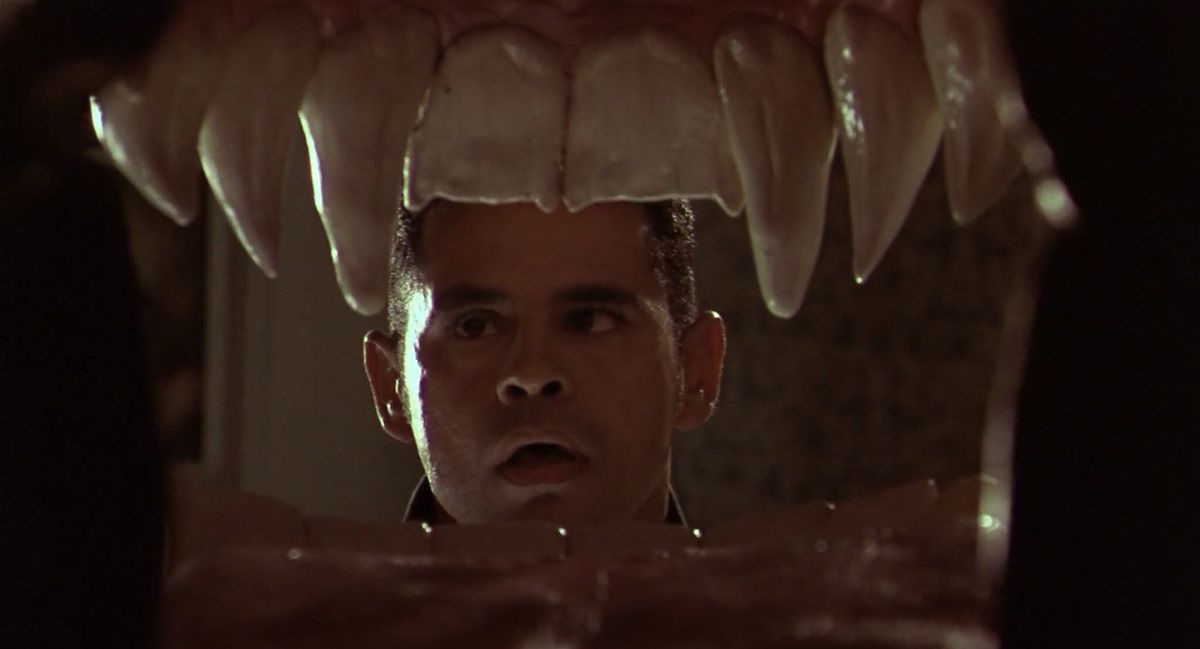 Un giovane Raymond Cruz fissa una bocca aperta con le zanne in From Dusk Till Dawn 2. La telecamera è da un punto di vista all'interno della bocca.