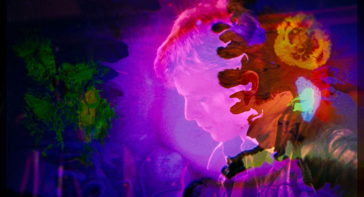 Il volto di un giovane David Bowie appare attraverso vorticosi spruzzi di viola e arancione in Moonage Daydream