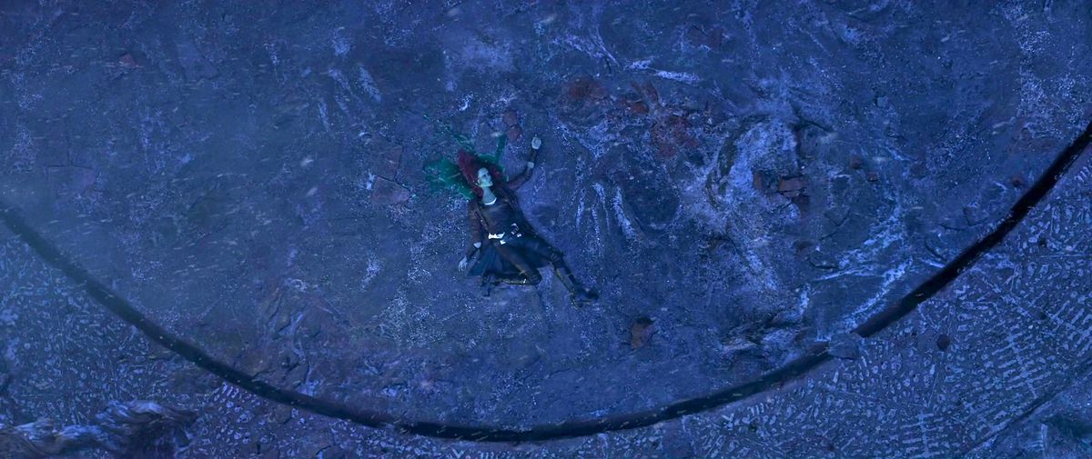 Gamora morta in fondo alla scogliera sacrificale Vormir Soul Stone che sanguina sangue verde sulla pietra in Avengers: Infinity War
