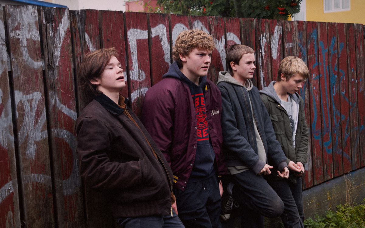 Un gruppo di giovani ragazzi nordici si appoggia a un muro pieno di graffiti in Beautiful Beings.