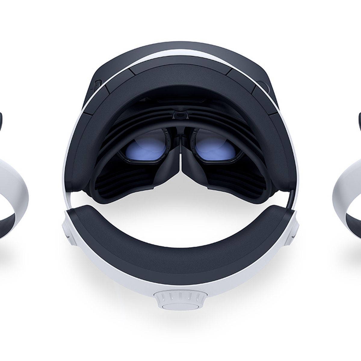 Il visore PSVR 2, visto dall'alto, appoggiato su una superficie bianca, affiancato da entrambi i controller VR2 Sense