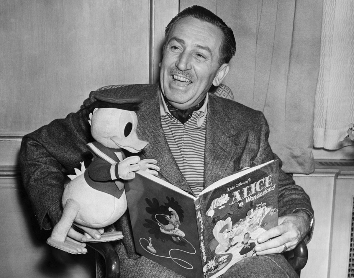 In un ritratto in bianco e nero del 1951, Walt Disney tiene in grembo un Paperino impagliato mentre legge una copia di Alice nel paese delle meraviglie
