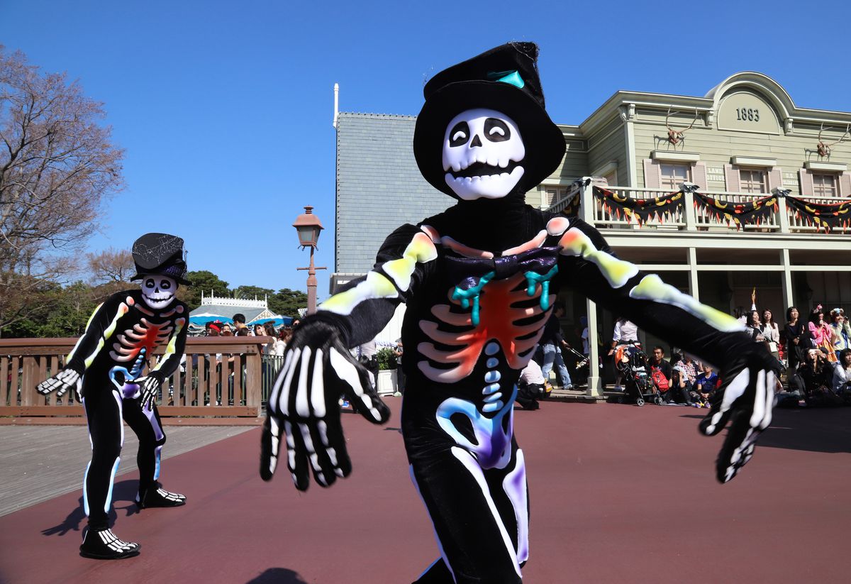 Ballerini vestiti da scheletri colorati si esibiscono durante la parata di Halloween a Tokyo Disneyland il 22 ottobre 2018