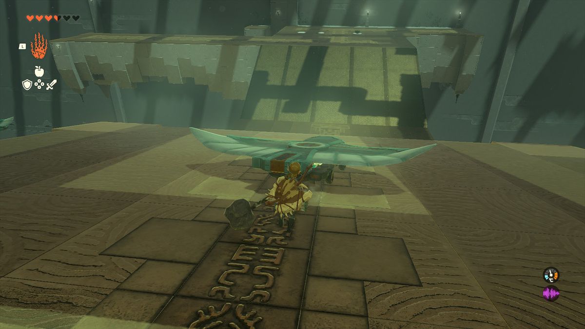 Link corre dietro a un carro con un'ala che rotola giù da una collina in Zelda Tears of the Kingdom.