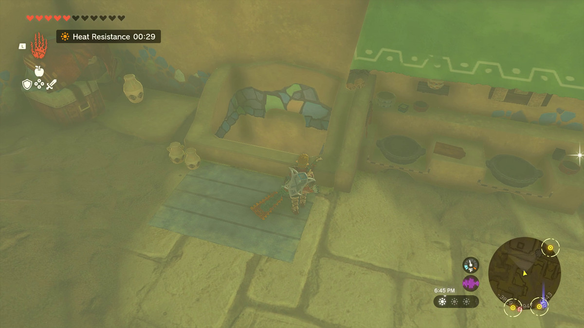 Link si avvicina a un pozzo Gerudo in Tears of the Kingdom, allestito accanto ad alcuni piani cottura e materiali