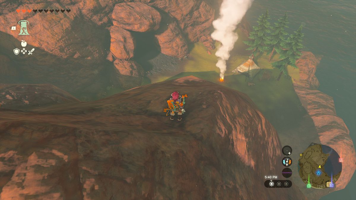 Link si affaccia dall'alto sull'ingresso della grotta del lago Cephla, in piedi su una scogliera in Zelda: Tears of the Kingdom