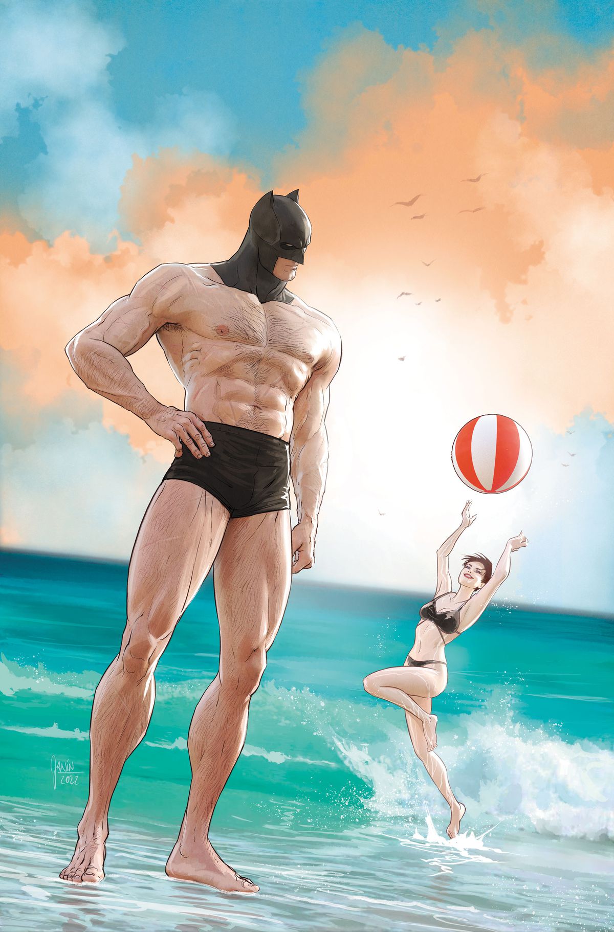 Batman è in piedi sulla spiaggia con indosso un piccolo set di costume da bagno e il suo cappuccio di Batman.  Dietro di lui, Catwoman gioca con un pallone da spiaggia. 