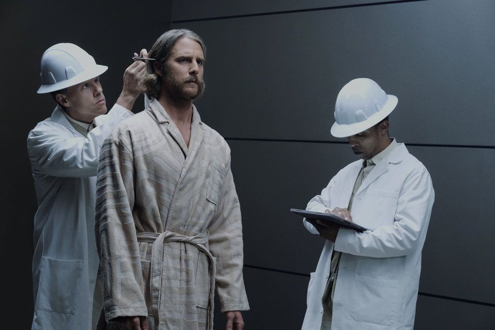 Wiley (Jake McDormand) viene ispezionato da due uomini in camice da laboratorio e elmetti in un fotogramma della stagione 1 di Mrs. Davis