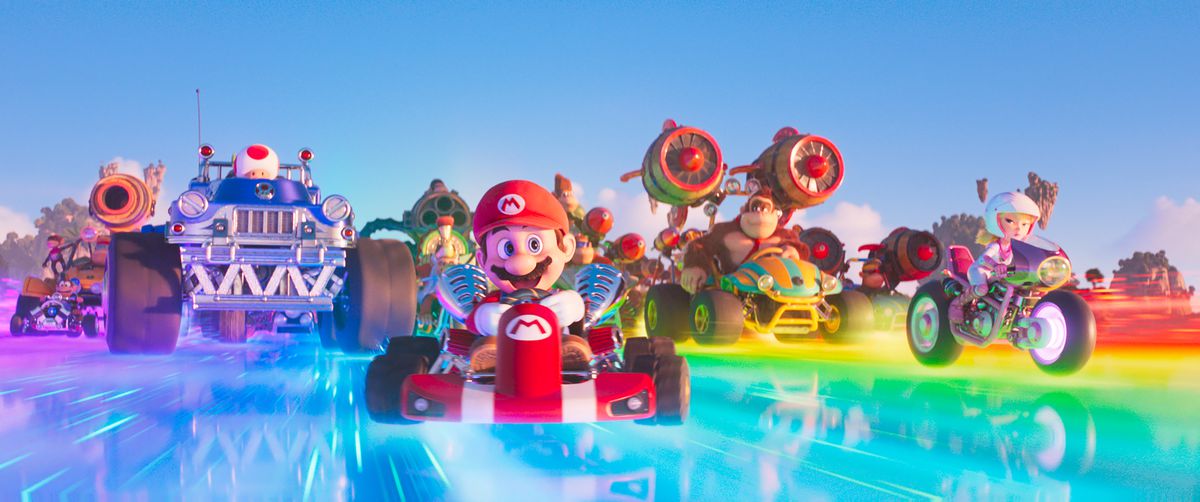 Mario e il cast del film di Mario Bros. nei loro veicoli Mario Kart mentre sfrecciano lungo Rainbow Road.