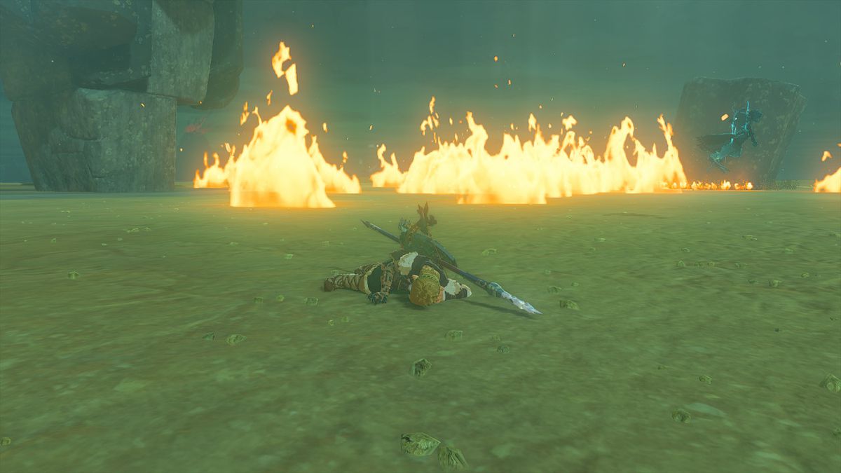 Link giace sul terreno basso morto contro uno scontro con il Flame Gleeok in Tears of the Kingdom.