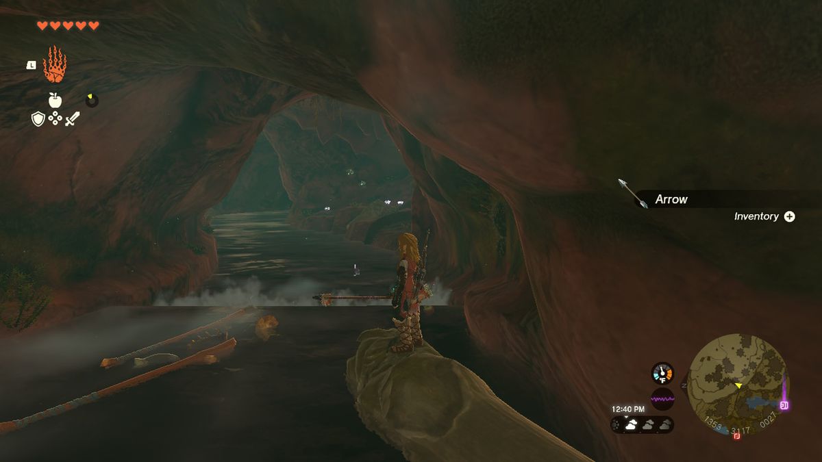 Link cavalca un tronco lungo un fiume in una grotta con l'armatura di gomma in Zelda Tears of the Kingdom.