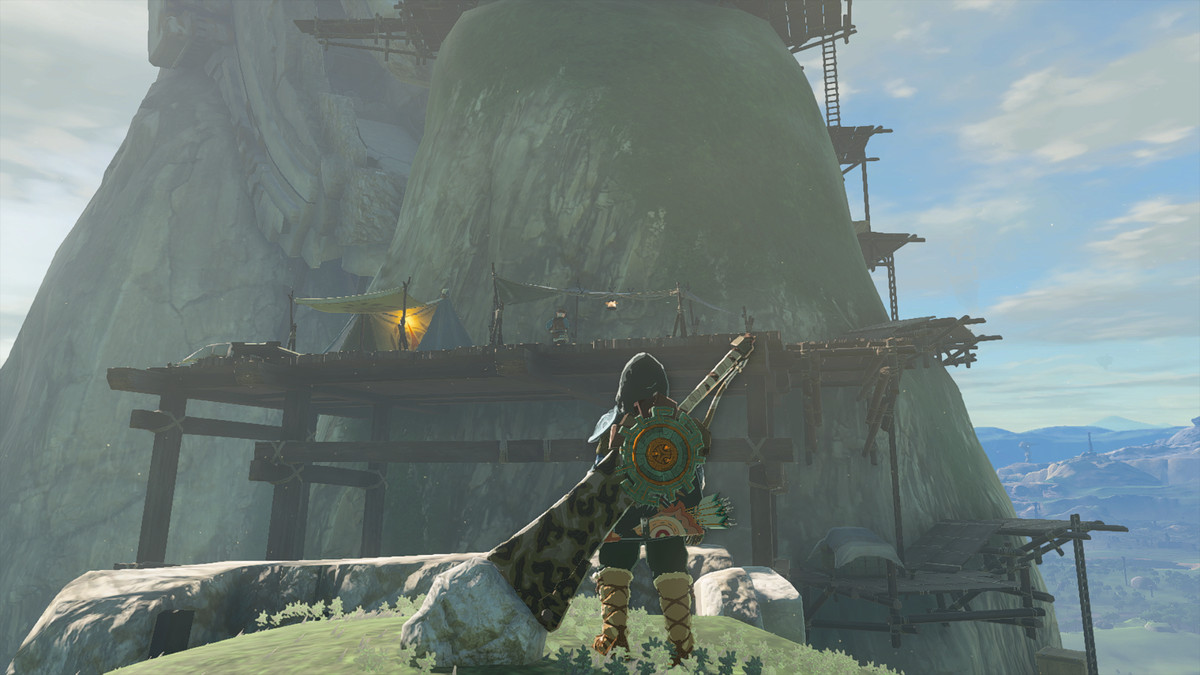 Link osserva un campo di rilevamento in The Legend of Zelda: Tears of the Kingdom.  C'è un'impalcatura costruita su una collina rocciosa.