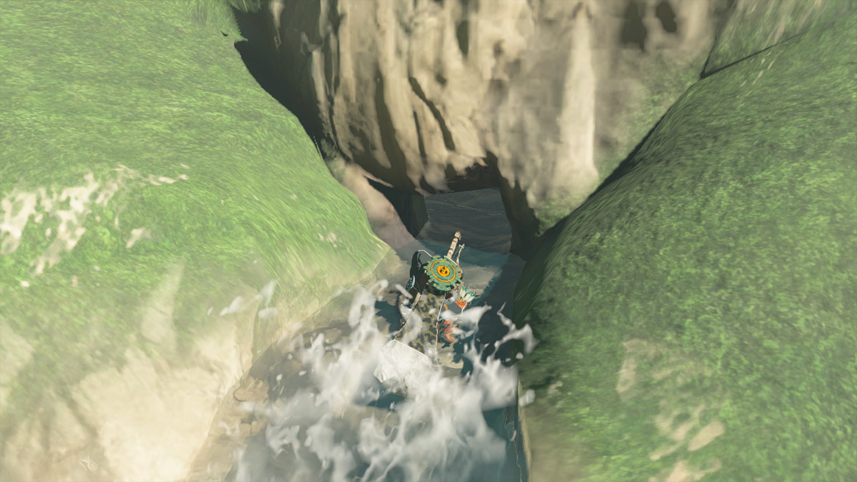 Link si accovaccia nell'acqua in The Legend of Zelda: Tears of the Kingdom.  La fonte delle cascate conduce a una grotta nascosta.