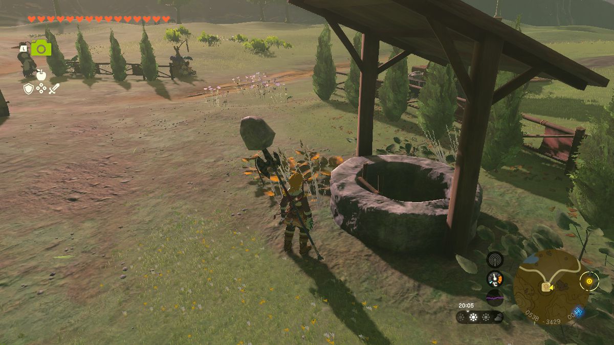 Link si trova accanto a un pozzo vicino alla scuderia delle Highland in Zelda Tears of the Kingdom.