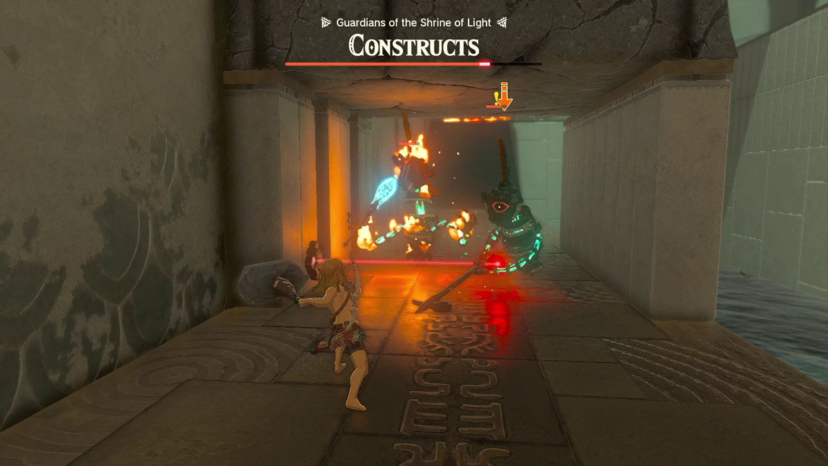 Due costrutti in viaggio per attaccare Link vengono bruciati da un dispositivo Zonai emettitore di fiamme nascosto dietro un raggio laser sotto un arco di pietra in Zelda: Tears of the Kingdom's Miryotanog Shrine