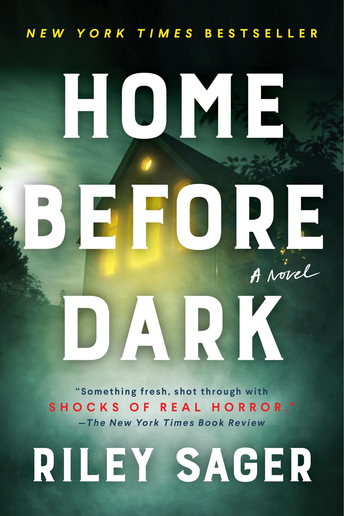 Immagine di copertina di Home Before Dark di Riley Sager, che mostra una casa con le luci accese oscurate dalla nebbia.