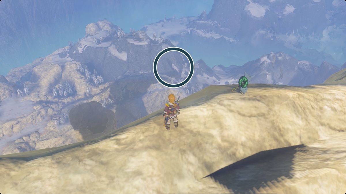 The Legend of Zelda: Tears of the Kingdom Link (e un Korok) in piedi sul trespolo di Van Medoh guardando a ovest.  Viene cerchiata una macchia che ora assomiglia a un uccello bianco su una montagna vicina