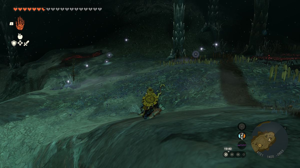 Link si accovaccia mentre cerca le lucciole nelle profondità in Zelda Tears of the Kingdom.
