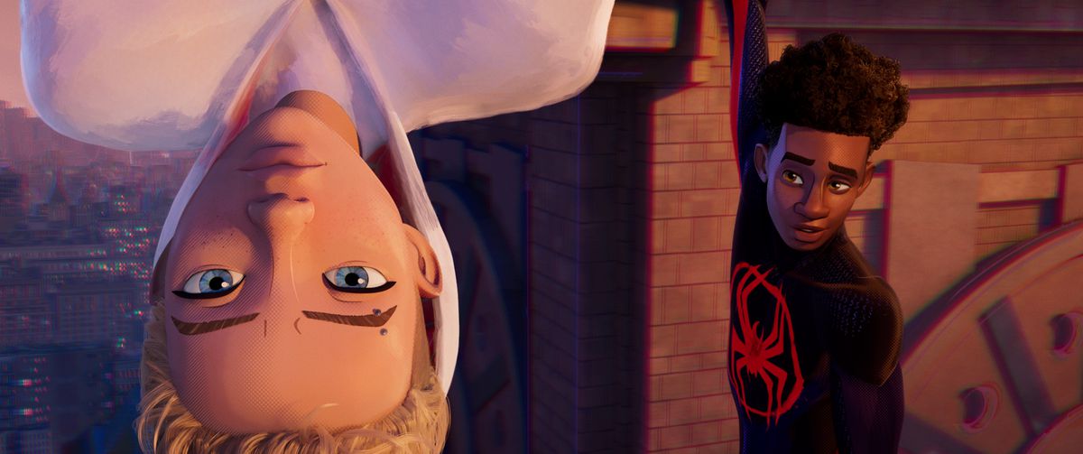 Gwen Stacy è appesa a testa in giù da un edificio in primo piano mentre Miles Morales le sorride dallo sfondo nel film d'animazione Spider-Man: Across the Spider-Verse
