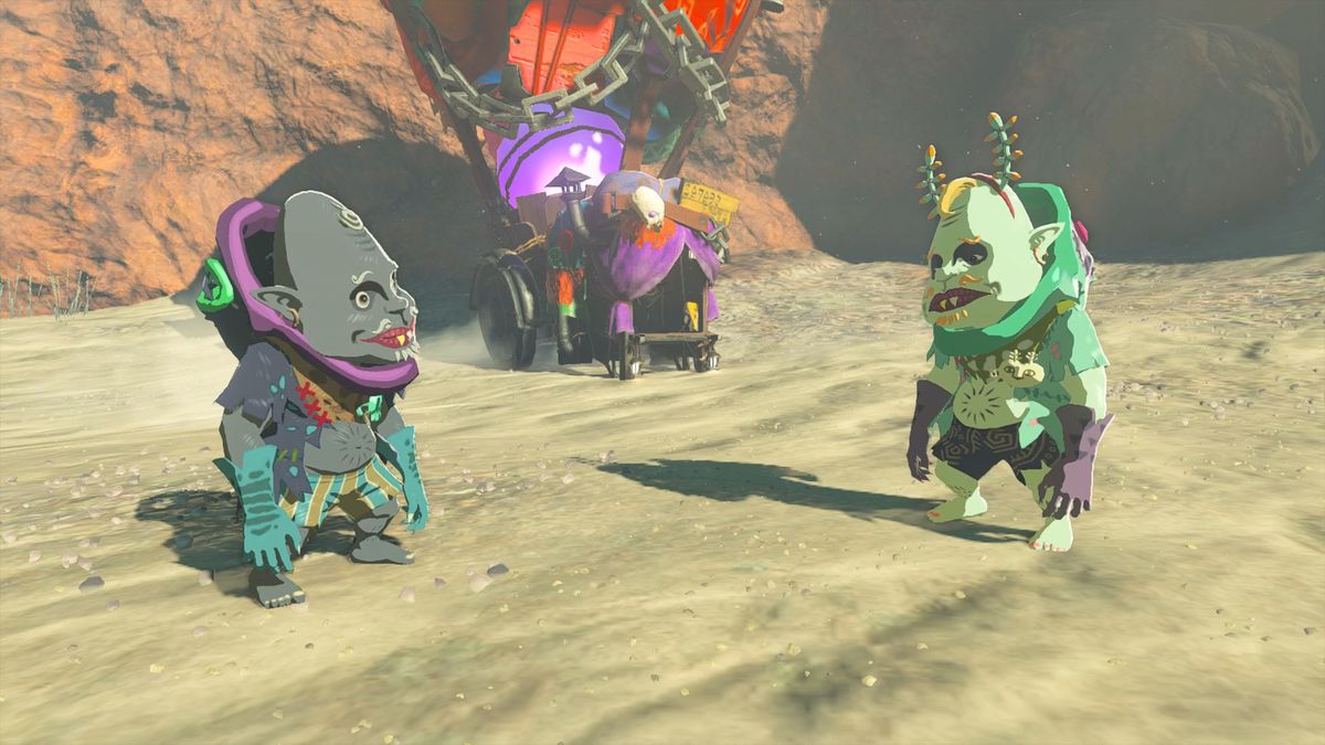 Kilton e Koltin in piedi su un terreno sabbioso davanti alla bancarella colorata di Koltin in The Legend of Zelda: Tears of the Kingdom