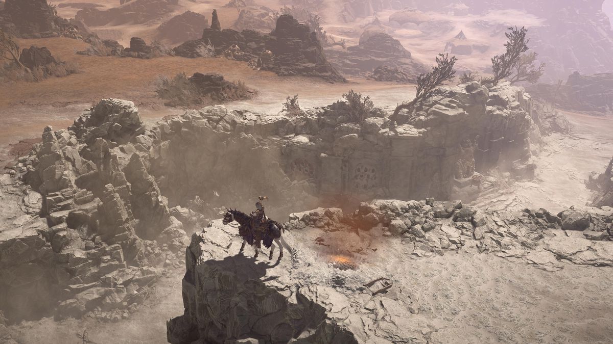 Un personaggio cavalca un cavallo fino alla sporgenza di un burrone che separa un paesaggio arido da una cupa distesa in Diablo 4