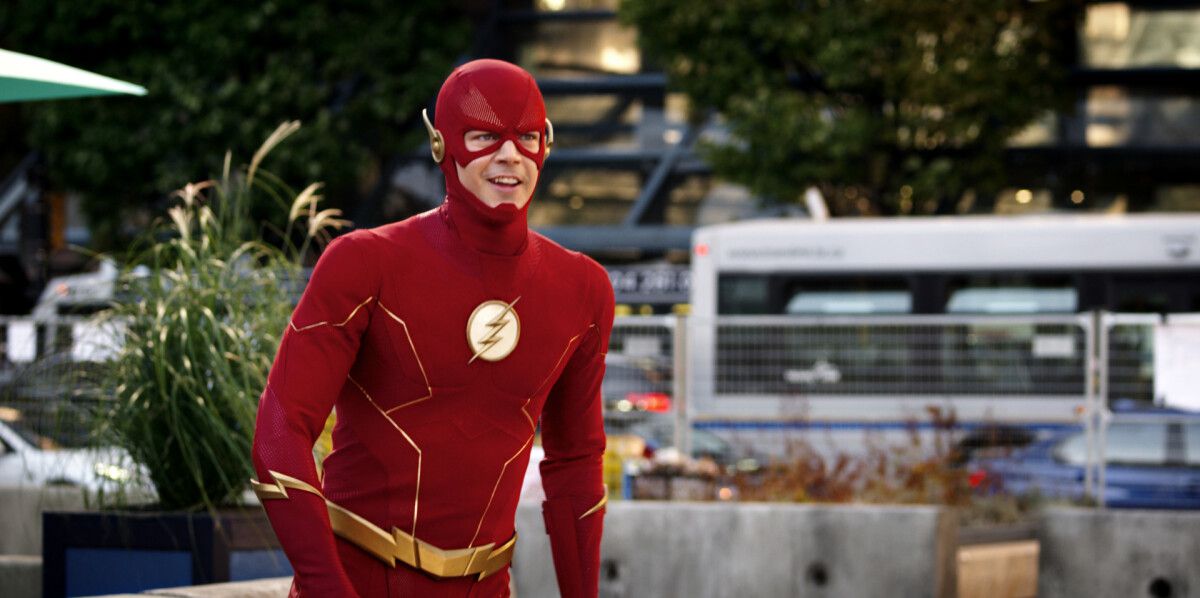 Grant Gustin nei panni di Flash in costume che sorride mentre sta per lanciarsi in uno sprint in The Flash di The CW