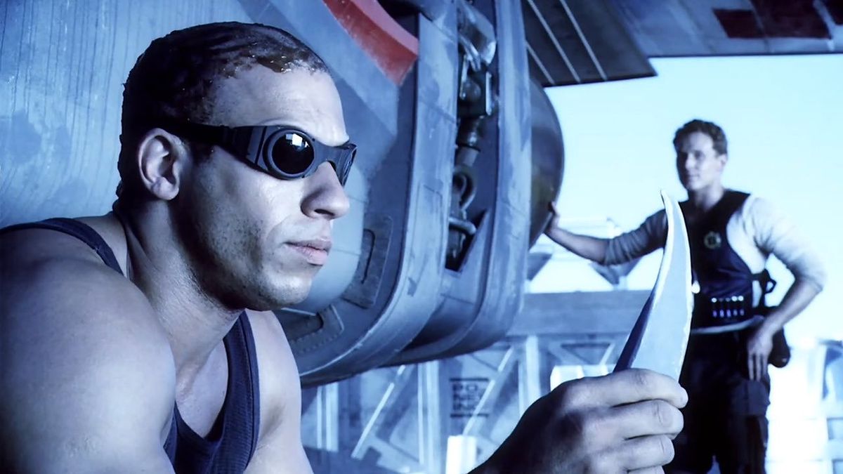 (LR) Richard B. Riddick (Vin Diesel) fissa un coltello con William J. Johns (Cole Hauser) sullo sfondo in Pitch Black.