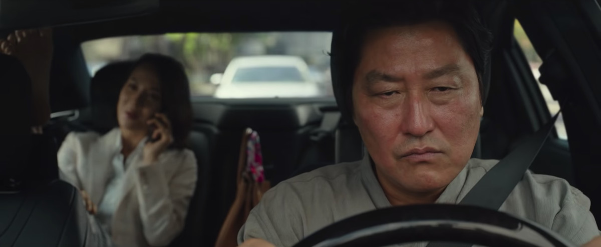 Il signor Kim (Song Kang-ho) guida un'auto ma è incazzato con Parasite