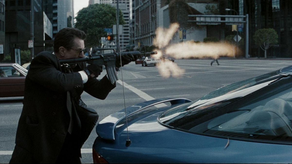 Neil McCauley (Robert De Niro) spara con un fucile M4A4 da dietro un'auto blu in un incrocio di Los Angeles, un lampo di volata che erutta visibilmente dalla canna del fucile in Heat.