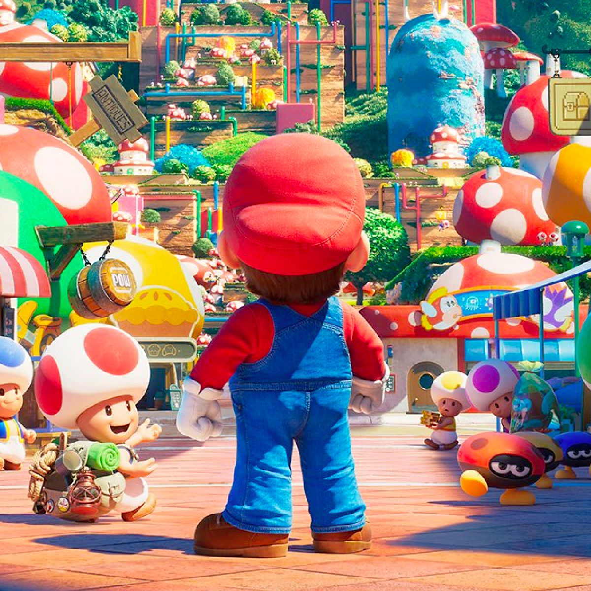 La schiena di Mario mentre si trova in un'affollata via commerciale popolata da Toads nel Regno dei Funghi