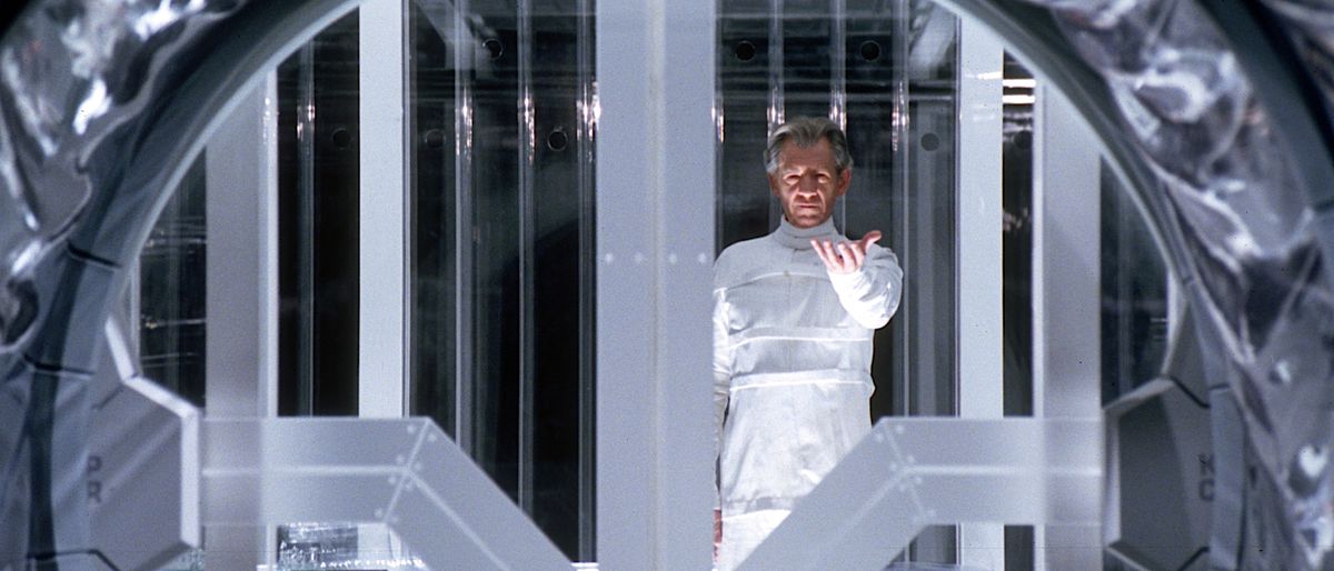 Magneto (Ian McKellan), tutto bianco, si trova nella sua prigione di vetro in X2: X-Men United e alza la mano, con il palmo rivolto verso l'alto, mentre inizia la sua fuga
