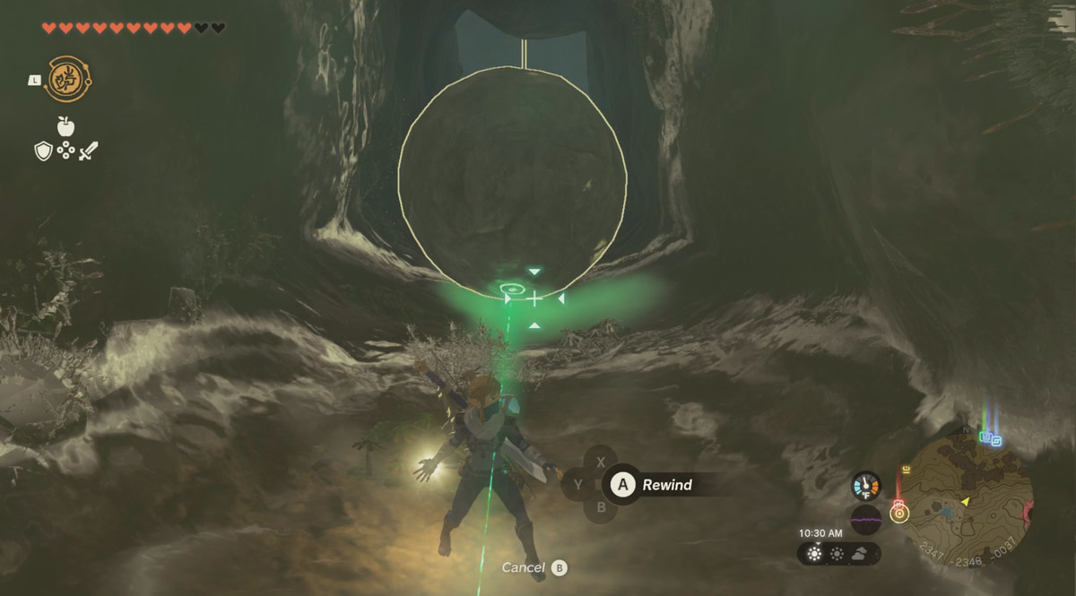 Link usando Recall su un masso che cade in The Legend of Zelda: Tears of the Kingdom.  Si trova in una caverna stretta e buia e il potere fa brillare di giallo l'ambiente circostante.