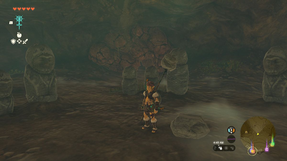 Link si trova dietro tre statue di pietra rivolte verso il percorso all'interno della caverna in Zelda: Tears of the Kingdom