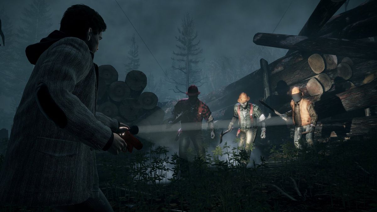 Alan Wake punta una torcia contro un gruppo di assalitori armati di ascia in Alan Wake: Remastered.